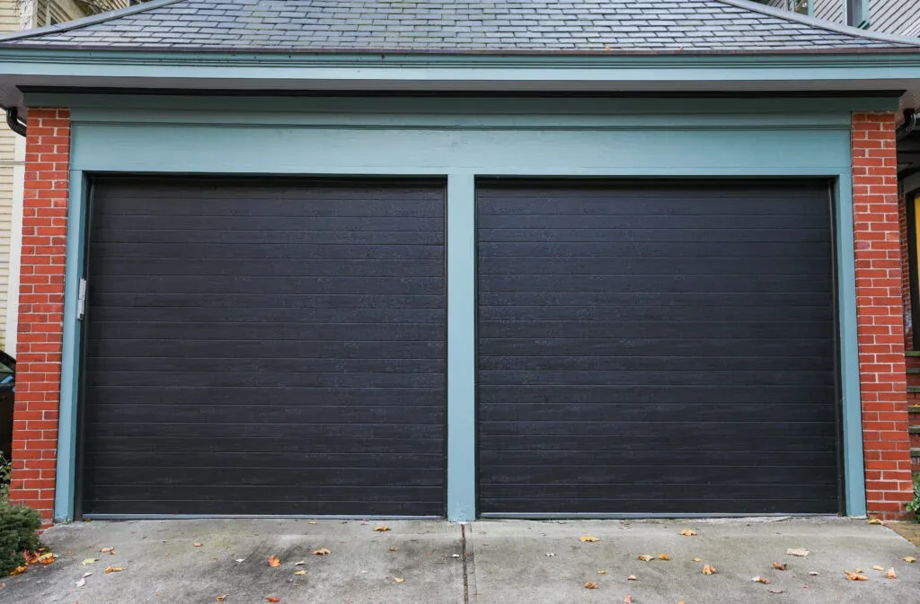 New dark steel garage door installed on a brick DFW home